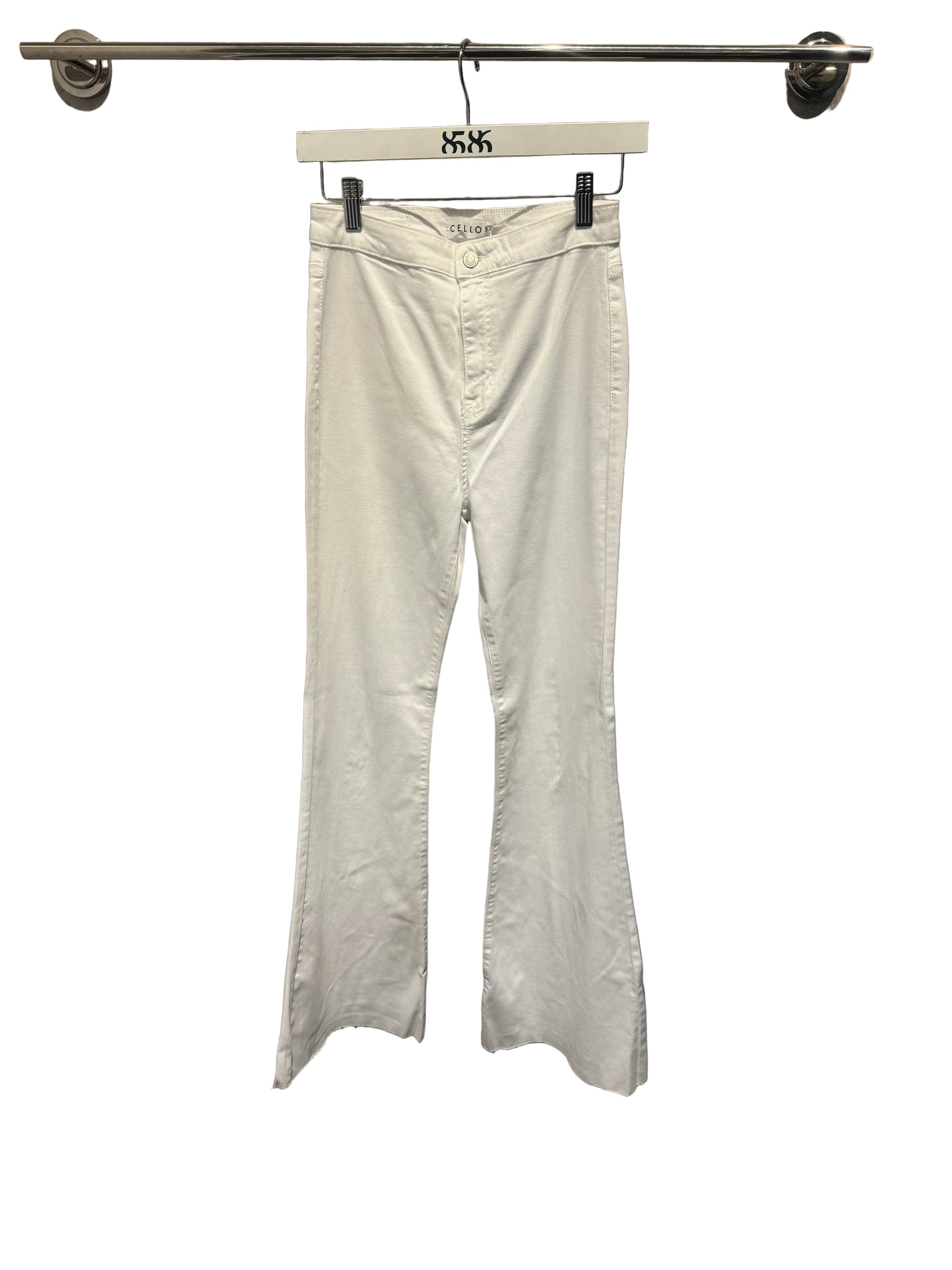 White pants hanging on a rack against a gray wall